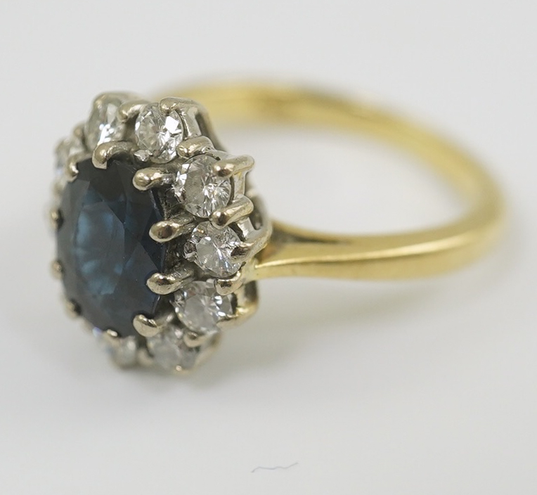 A modern 18ct gold, sapphire and diamond set oval cluster ring